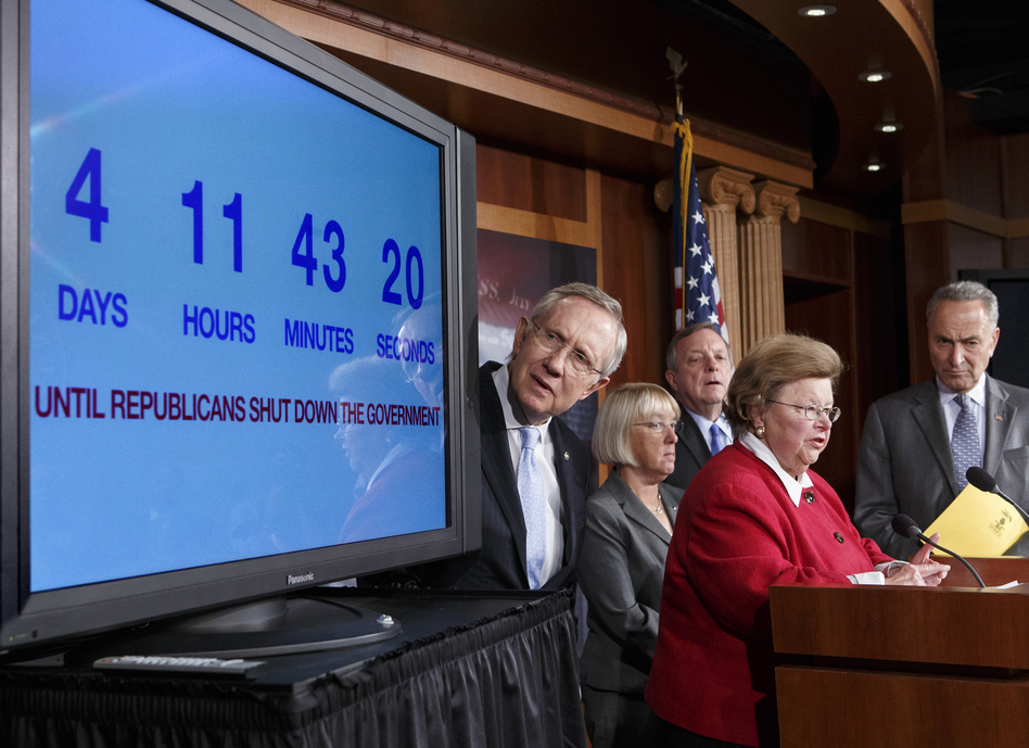 Senate Majority Leader Harry Reid, D-Nev., looks at a countdown-to-shutdown clock during a news conference in the Capitol on Thursday. (J. Scott Applewhite/AP)