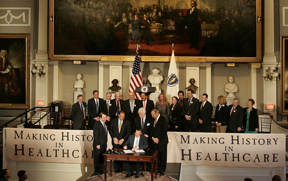Then-Gov. Mitt Romney signs the Massachusetts health care bill in Boston on April 12, 2006. (Brian Snyder/Reuters/Landov)