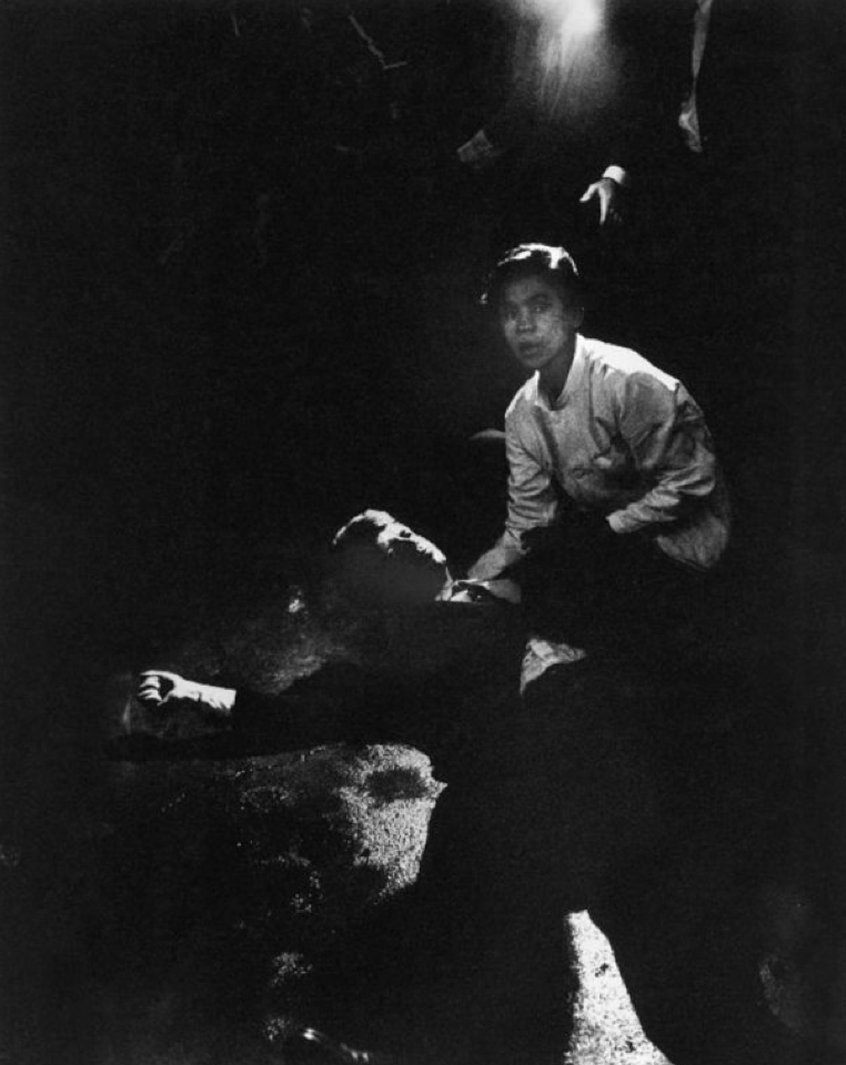 Rigid, semiconscious, his face an ashen mask, Kennedy lies in a pool of his own blood on the concrete floor, a bullet deep in his brain and another in his neck. Juan Romero, a busboy whose hand Kennedy had shaken before the shots, tried to comfort him. (Courtesy of Time & Life Pictures/Getty Images)
