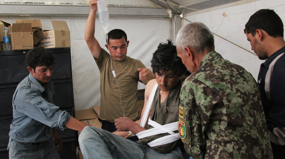 Afghan medics at Forward Operating Base Nolay in the southern province of Helmand treat an Afghan police officer shot by militants. (Sean Carberry/NPR)