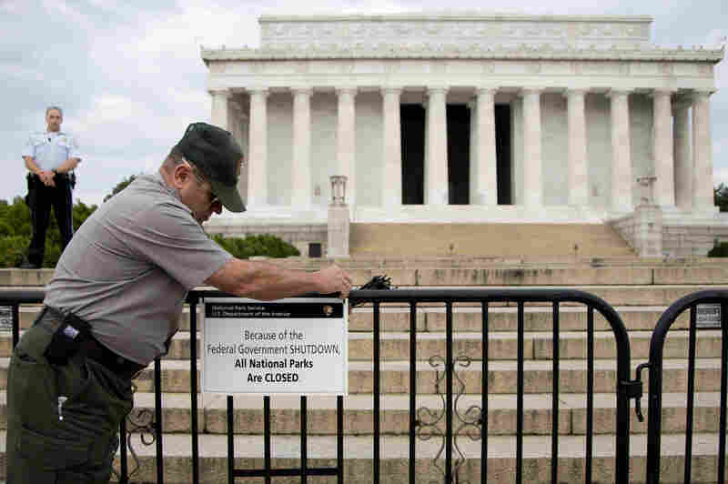A National Park Service employee posts a sign on a barricade in front of the Lincoln Memorial in Washington, D.C., on Oct. 1, the first day of the U.S. government shutdown.