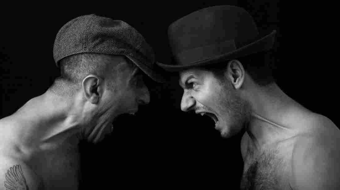 Two mean yelling at each other, face to face.