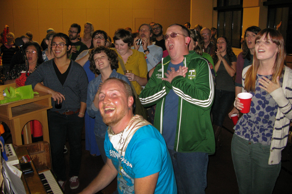 Todd Fadel, at piano, leads singers at a recent gathering of Beer & Hymns at First Christian Church Portland. (John Burnett/NPR)