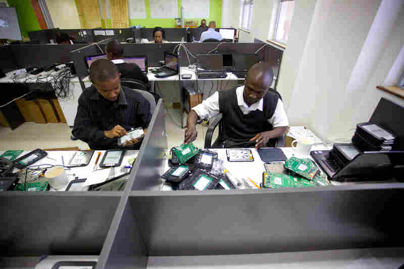 Workers at Bridge's headquarters prepare tablets for use in the school chain's classrooms.