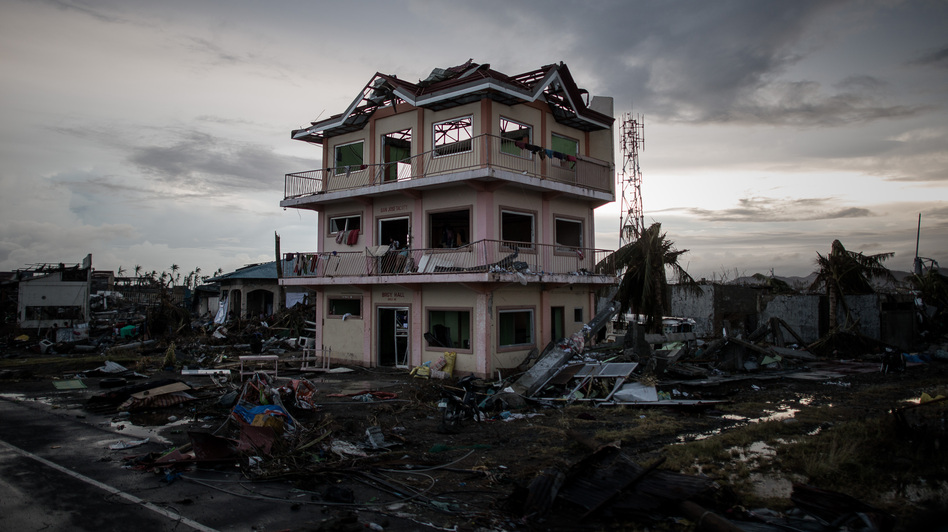 The sun sets behind a house damaged by Typhoon Haiyan outside the hard-hit city of Tacloban. The Philippines has gotten better at preparing for typhoons, but remains extremely vulnerable. (Philippe Lopez/AFP/Getty Images)