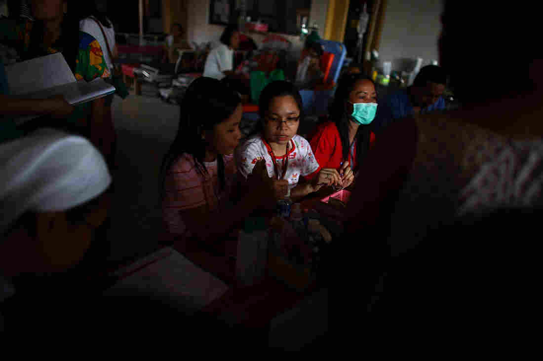 Nurses at Divine Word Hospital in Tacloban, Philippines, do their best to organize a list of patients seeking medical attention.