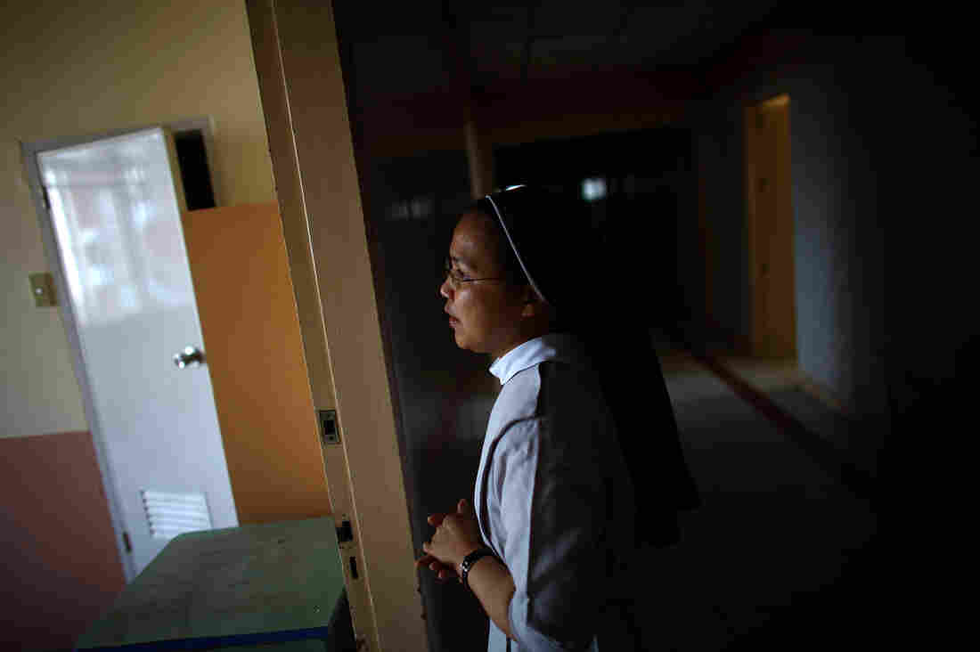 Sister Eliza Arpon checks on the condition of the damaged ward rooms and ER facilities at Divine Word Hospital in Tacloban, Philippines, on Saturday.