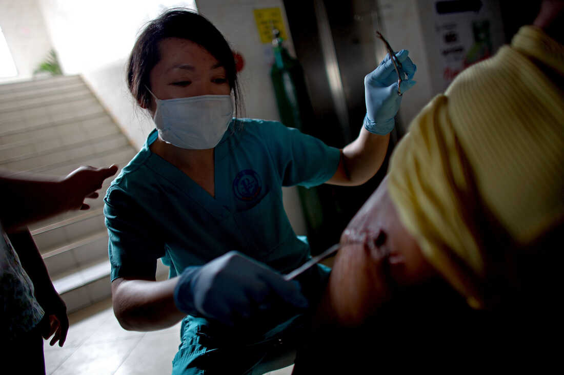 A doctor operates on an injured man in the hallways of the Divine Word Hospital in Tacloban, Philippines, on Saturday.