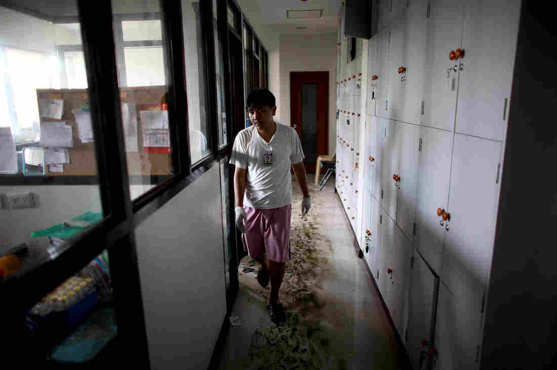 A worker walks through mud and water in the hallways of the Divine Word Hospital in Tacloban, Philippines, on Saturday.
