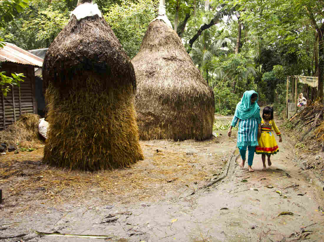 Minu in the village with 7-year old daughter, Sumaiya. Sumaiya lives here with Minu's parents.