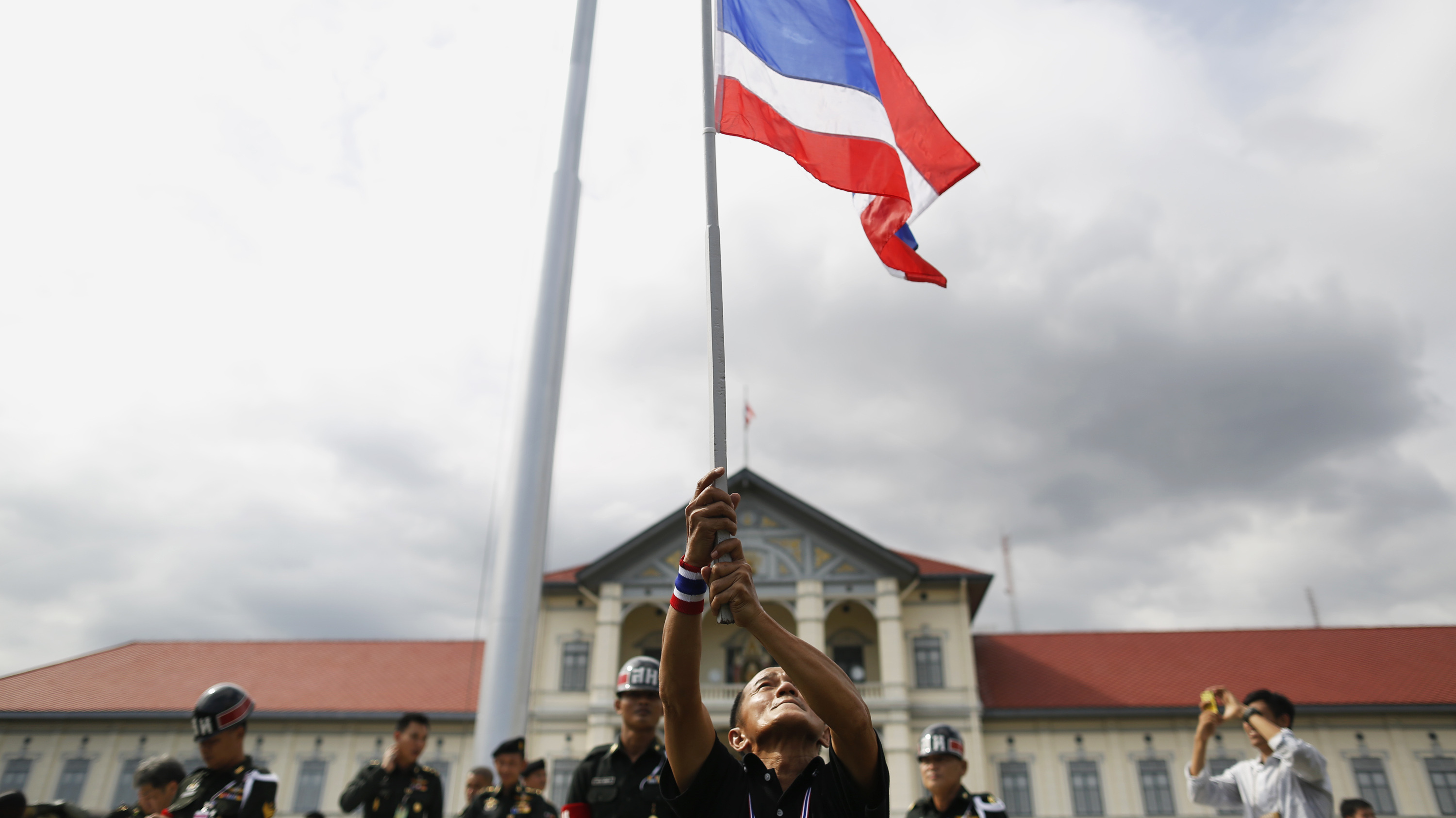 An anti-government protester waves a national flag after breaking into the compound of the Royal Thai Army headquarters in Bangkok on Friday. (Reuters /Landov)