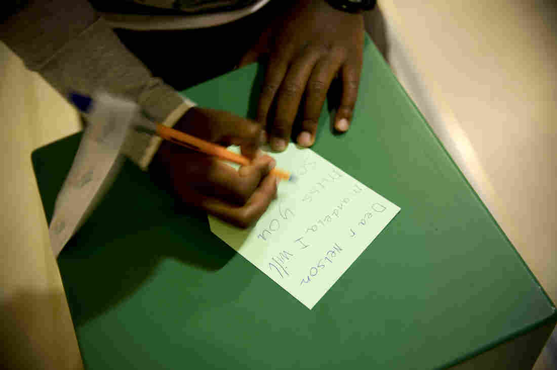 A young boy writes a goodbye message to Mandela at Cape Town's Civic Center Nelson Mandela exhibition. The exhibition opened earlier this year in celebration of Mandela's 95th birthday.