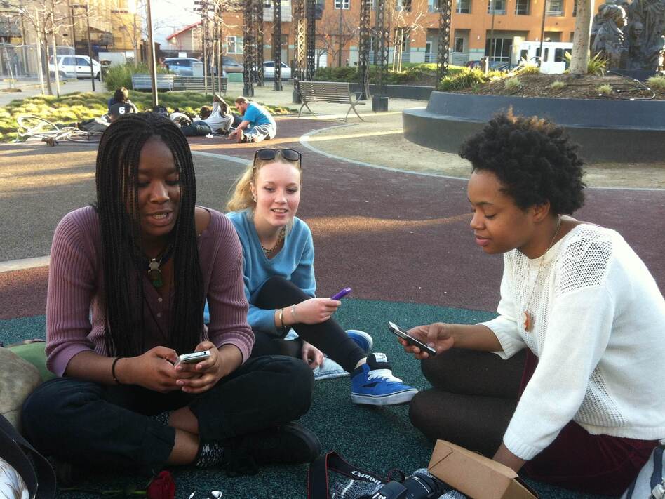 Three high school students in Oakland, Calif., swap photos using Snapchat. (Ike Sriskandarajah/Youth Radio)