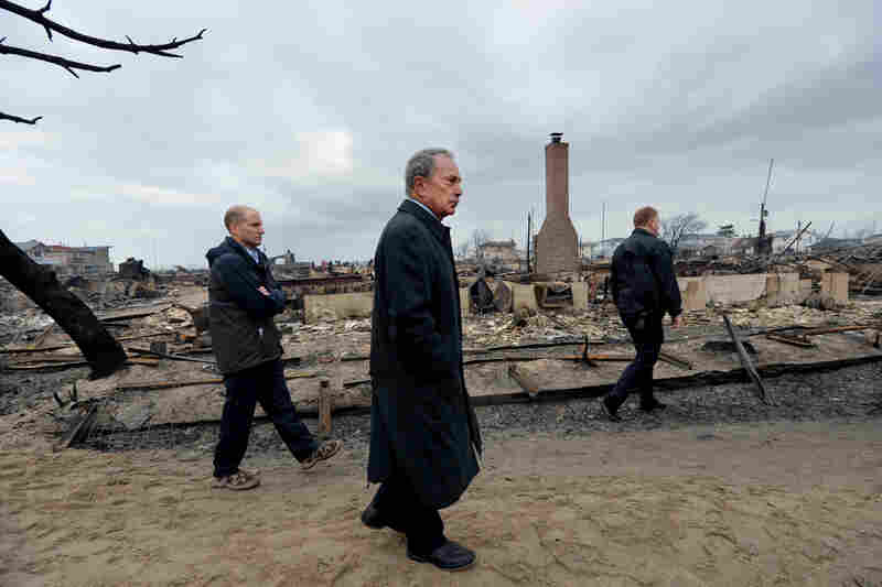 Bloomberg (center) views the Breezy Point area of Queens on Oct. 30, 2012, after fire destroyed about 80 homes as a result of Hurricane Sandy, which hit the area a day earlier.