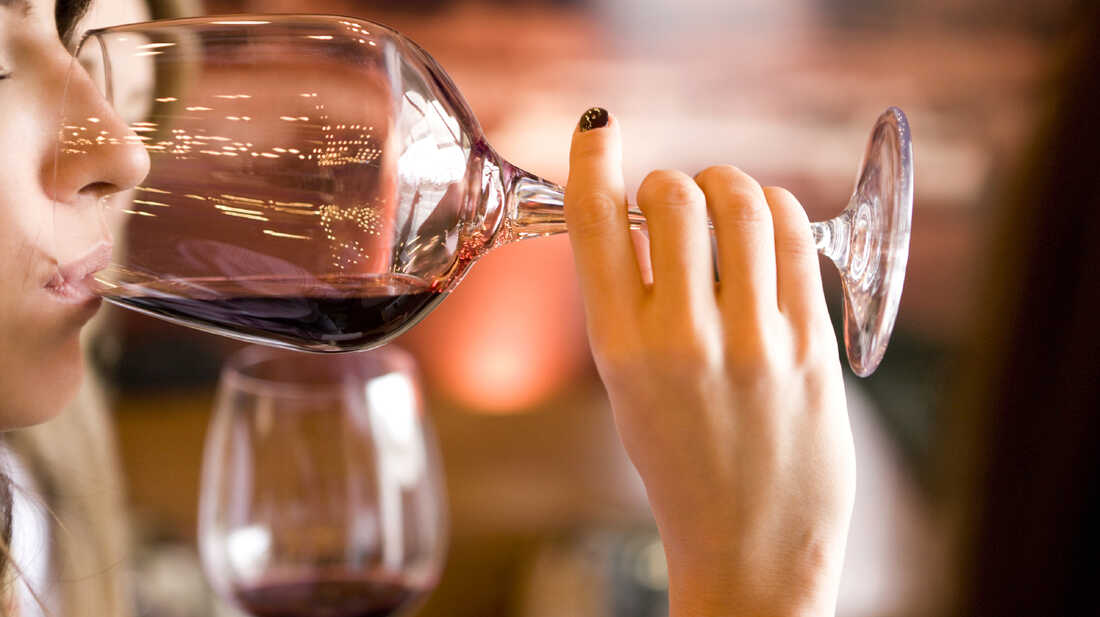 A woman drinks from a wine glass