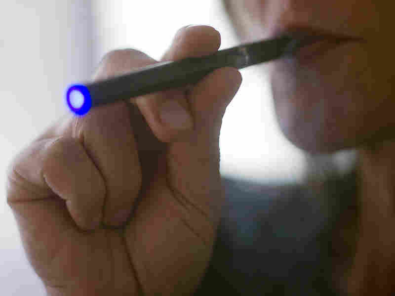 Photo illustration of a woman smoking an e-cigarette