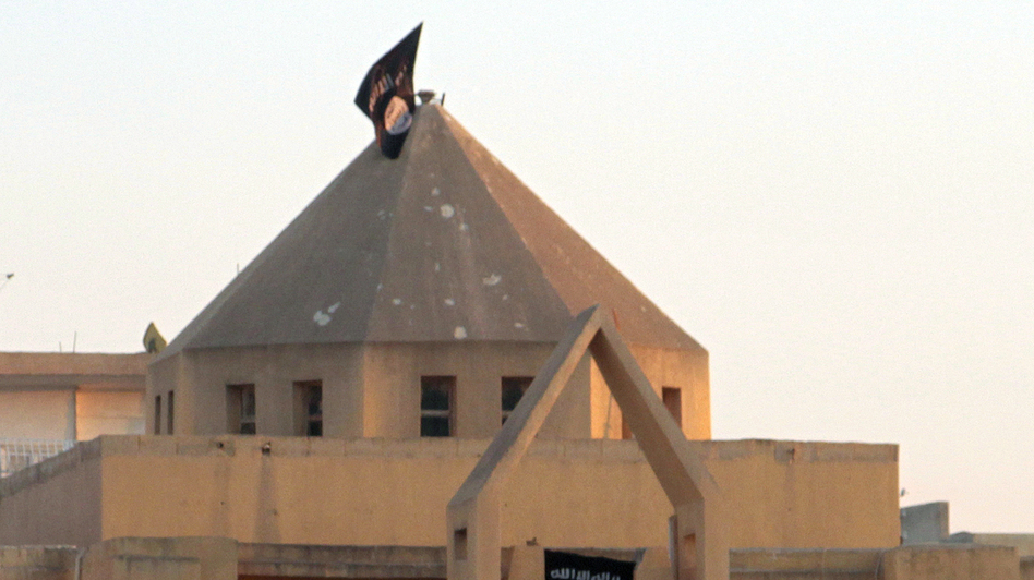 The flag of the Islamic State of Iraq and Syria, or ISIS, flutters on the dome of an Armenian Catholic Church in the northern rebel-held Syrian city of Raqqa on Sept. 28, 2013. At first, Syrian rebels and civilians welcomed the experienced Islamist fighters, and the groups fought together to take over the city from Syrian troops. Now, many Syrians fear and resent ISIS. (AFP/Getty Images)