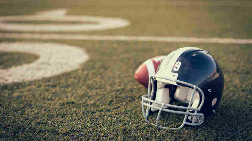 A football helmet and football on the football field.