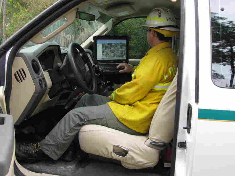 Chris Wasil, a forest area supervisor for Palm Beach County, demonstrates how satellite maps depict the location and movement of fire equipment.