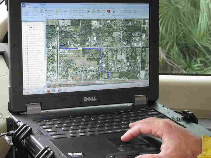 Chris Wasil, a forest area supervisor for Palm Beach County, demonstrates how satellite maps depict the location and movement of fire equipment.