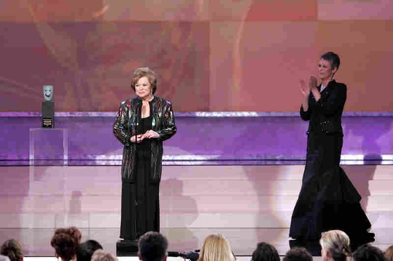Temple accepts the Screen Actors Guild annual life achievement award in 2006 as presenter Jamie Lee Curtis applauds.