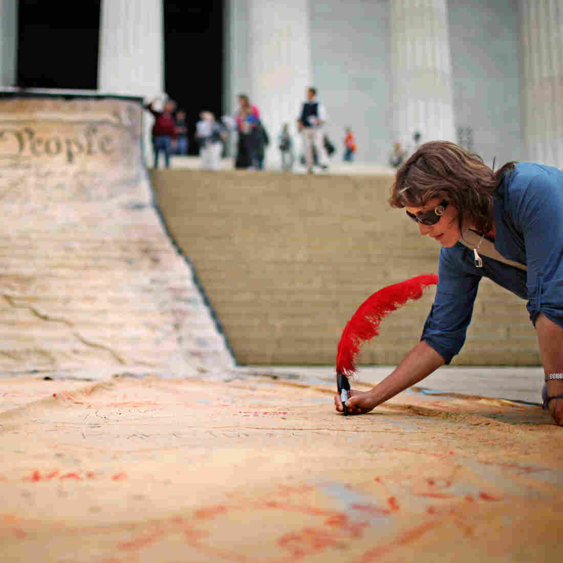 A woman signs a giant banner printed with the preamble to the U.S. Constitution during a demonstration against the Citizens United ruling in Washington in October 2010. A woman signs a giant banner printed with the preamble to the U.S. Constitution during a demonstration against the Citizens United ruling in Washington in October 2010.