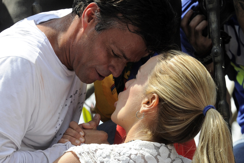 Leopoldo López, an ardent opponent of Venezuela's socialist government facing an arrest warrant after President Nicolas Maduro ordered his arrest on charges of homicide and inciting violence, kisses his wife Lilian Tintori, before turning himself in to authorities on Tuesday. (Leo Ramirez/AFP/Getty Images)