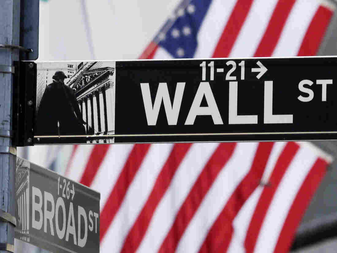 Image #: 21481811 The American Flag can be seen behind a sign for Wall Street near the New York Stock Exchange in New York City on March 5, 2013. UPI/John Angelillo /LANDOV