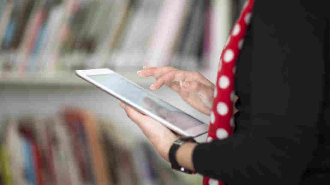 A woman holds an e-book reader.