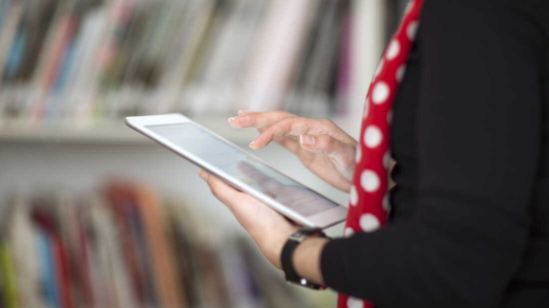 A woman holds an e-book reader.