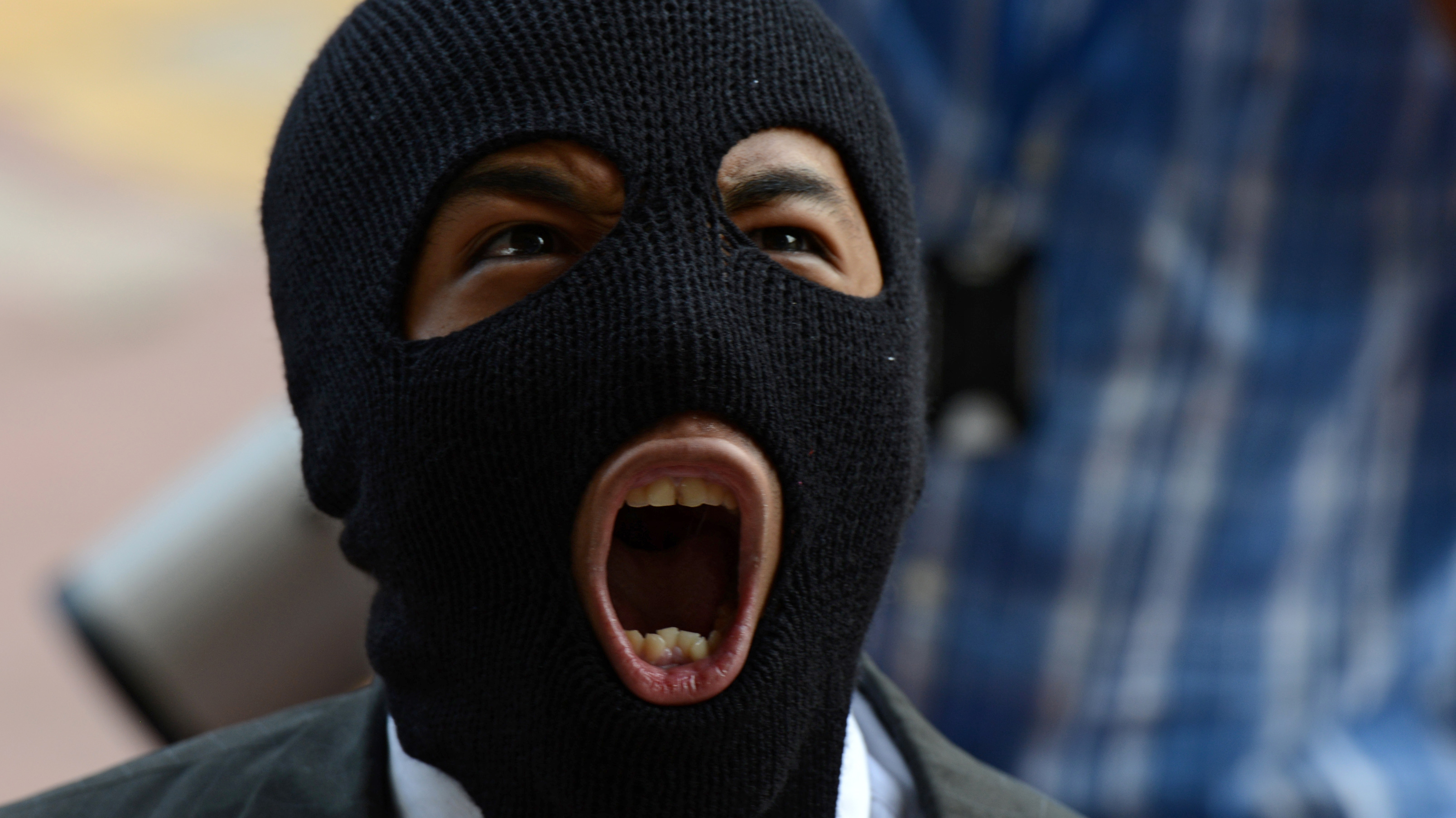 A balaclava-clad protester shouts anti-government slogans during a rally in Honduras. (AFP/Getty Images)