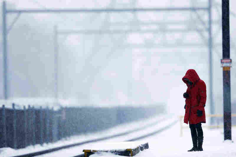 A commuter waits for a train as snow falls in Philadelphia.