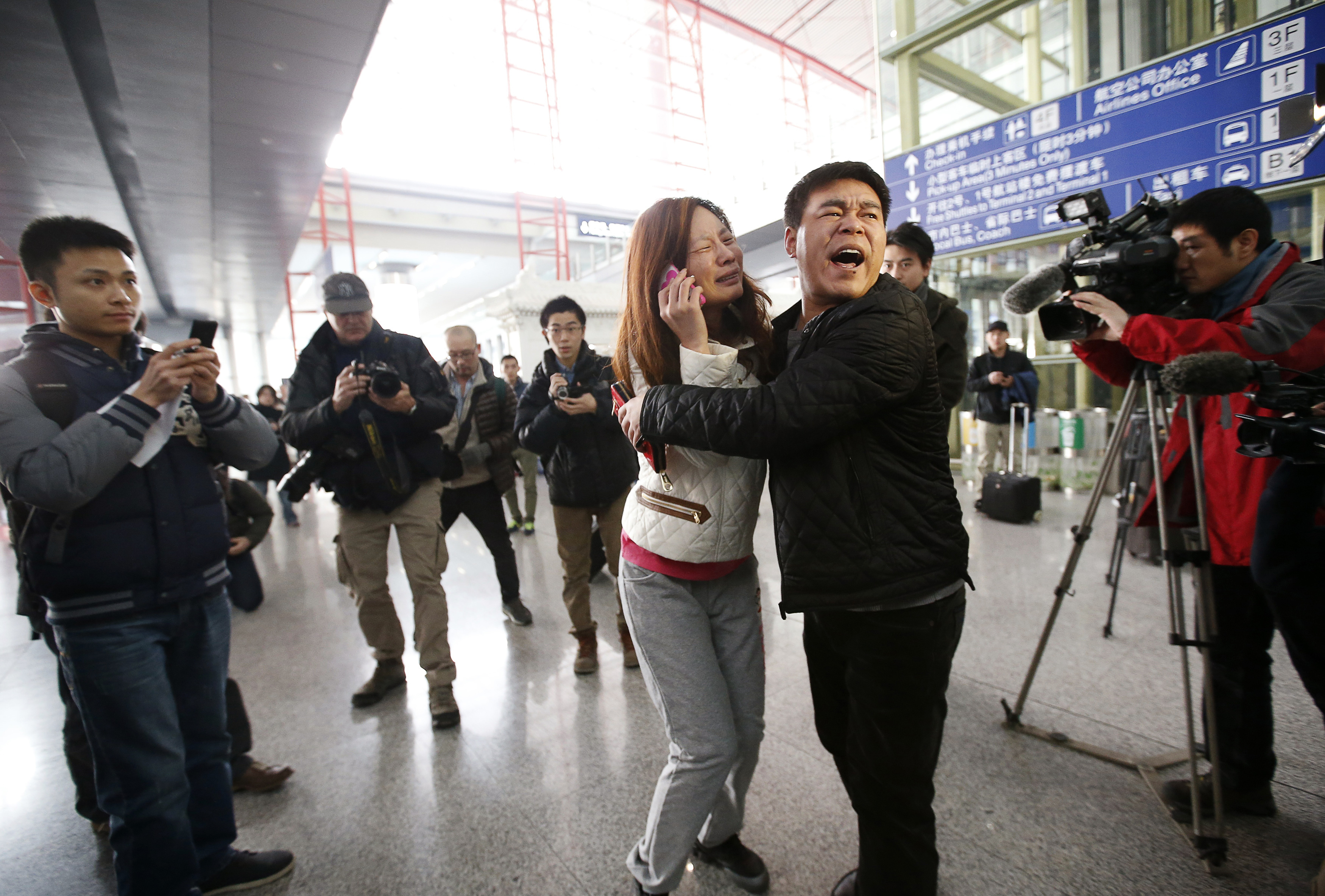 A woman, believed to be the relative of a passenger onboard Malaysia Airlines flight MH370, cries as she talks on her mobile phone at the Beijing Capital International Airport in Beijing.