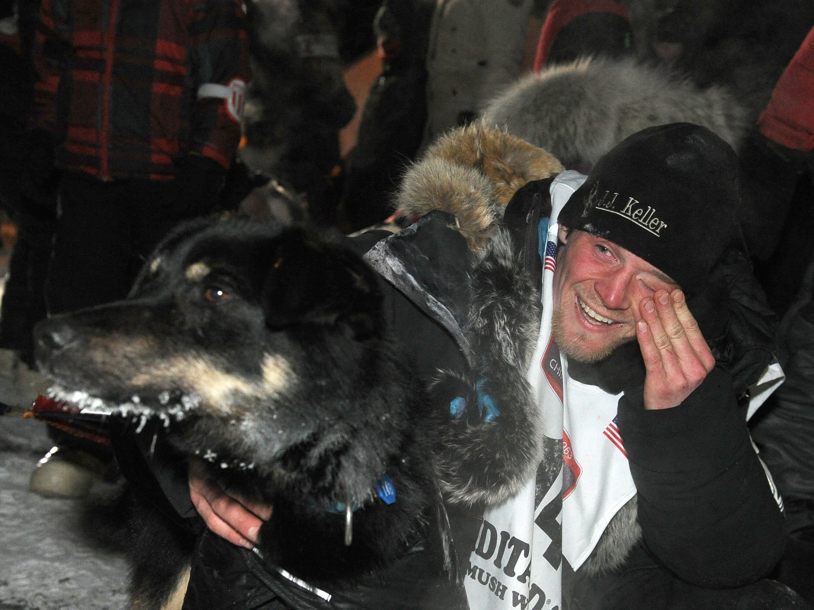 Dallas Seavey with his lead dog Beatle after crossing under the burled arch in Nome, Alaska, to win the 2014 Iditarod Trail Sled Dog Race on Tuesday.