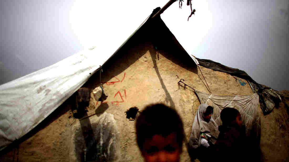 Children gather outside of their mud walled home in the Nasaji Bagrami camp for internally displaced Afghans in Kabul.