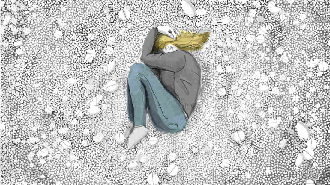 A woman lies in the fetal position.