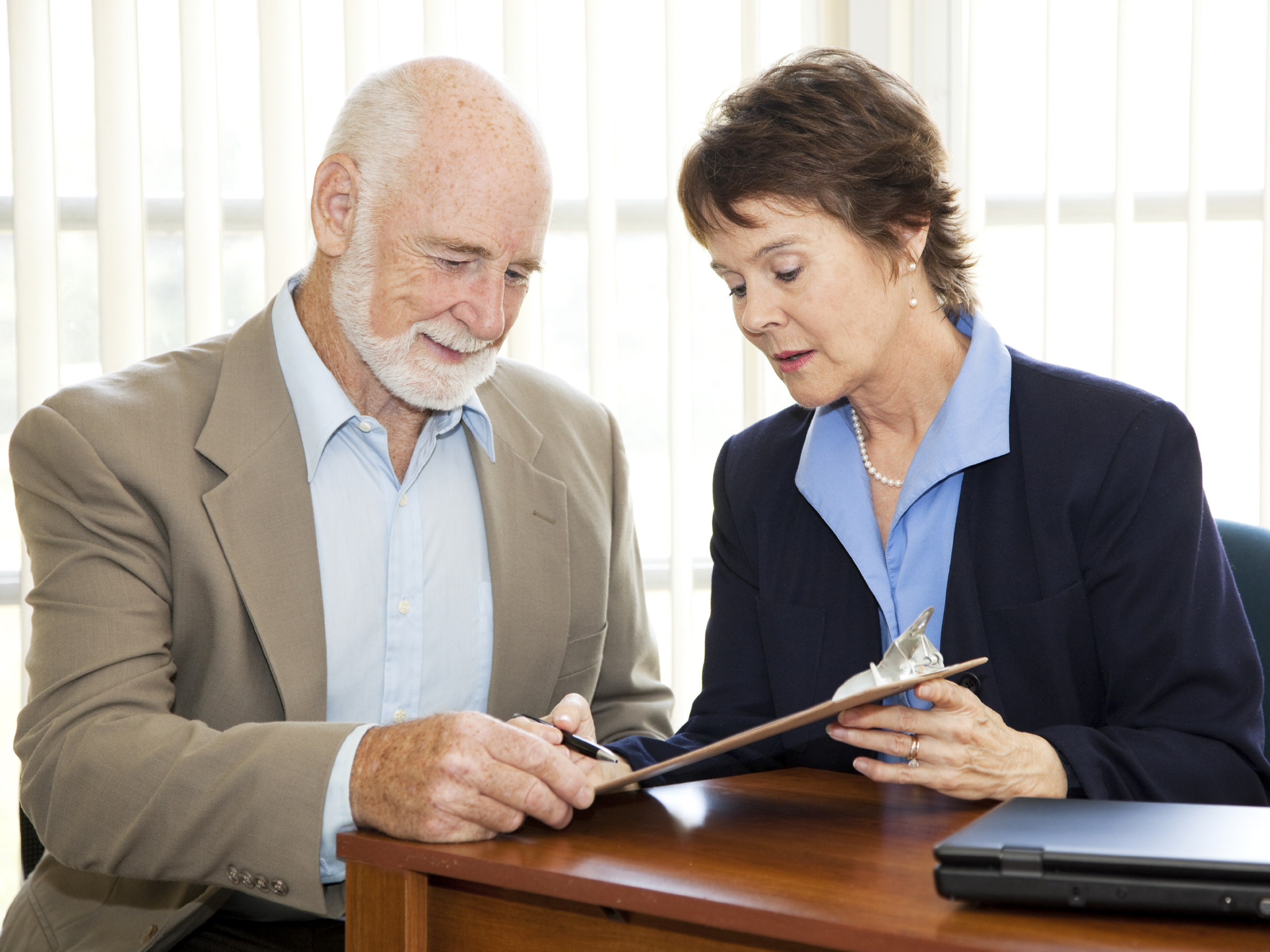 Man signing a contract in his attorney's office. (iStockPhoto)