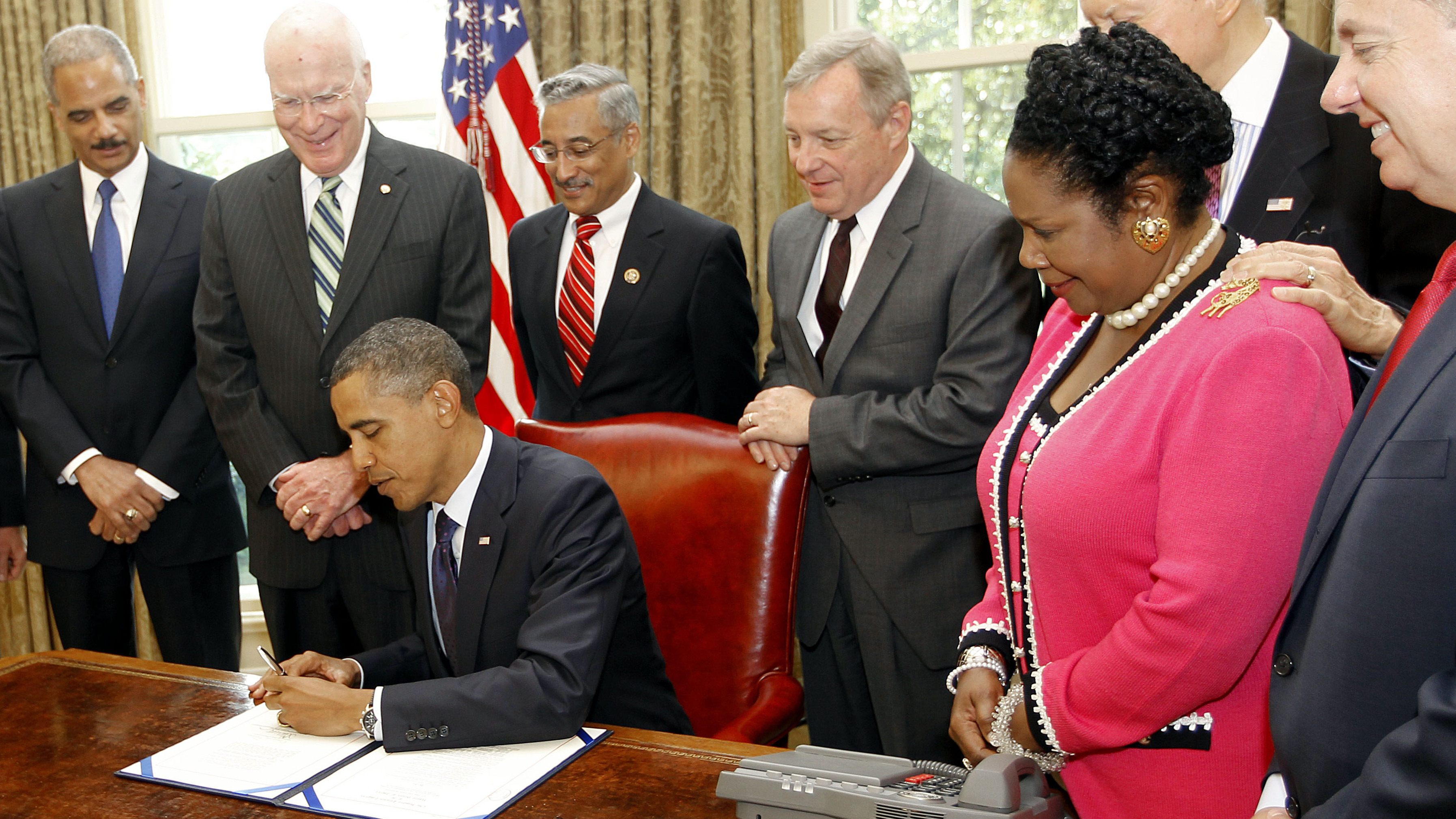 President Obama signs the Fair Sentencing Act in 2010, as Attorney General Eric Holder and a bipartisan group of senators look on.