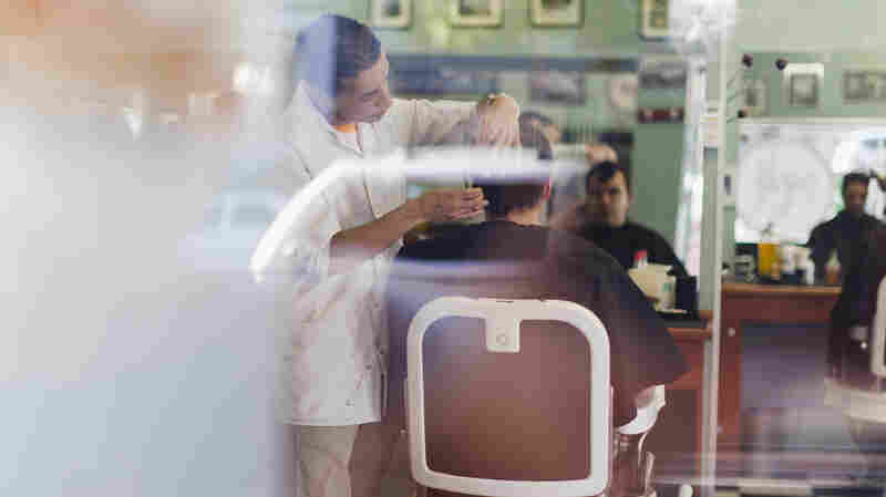 Barber working on client in shop