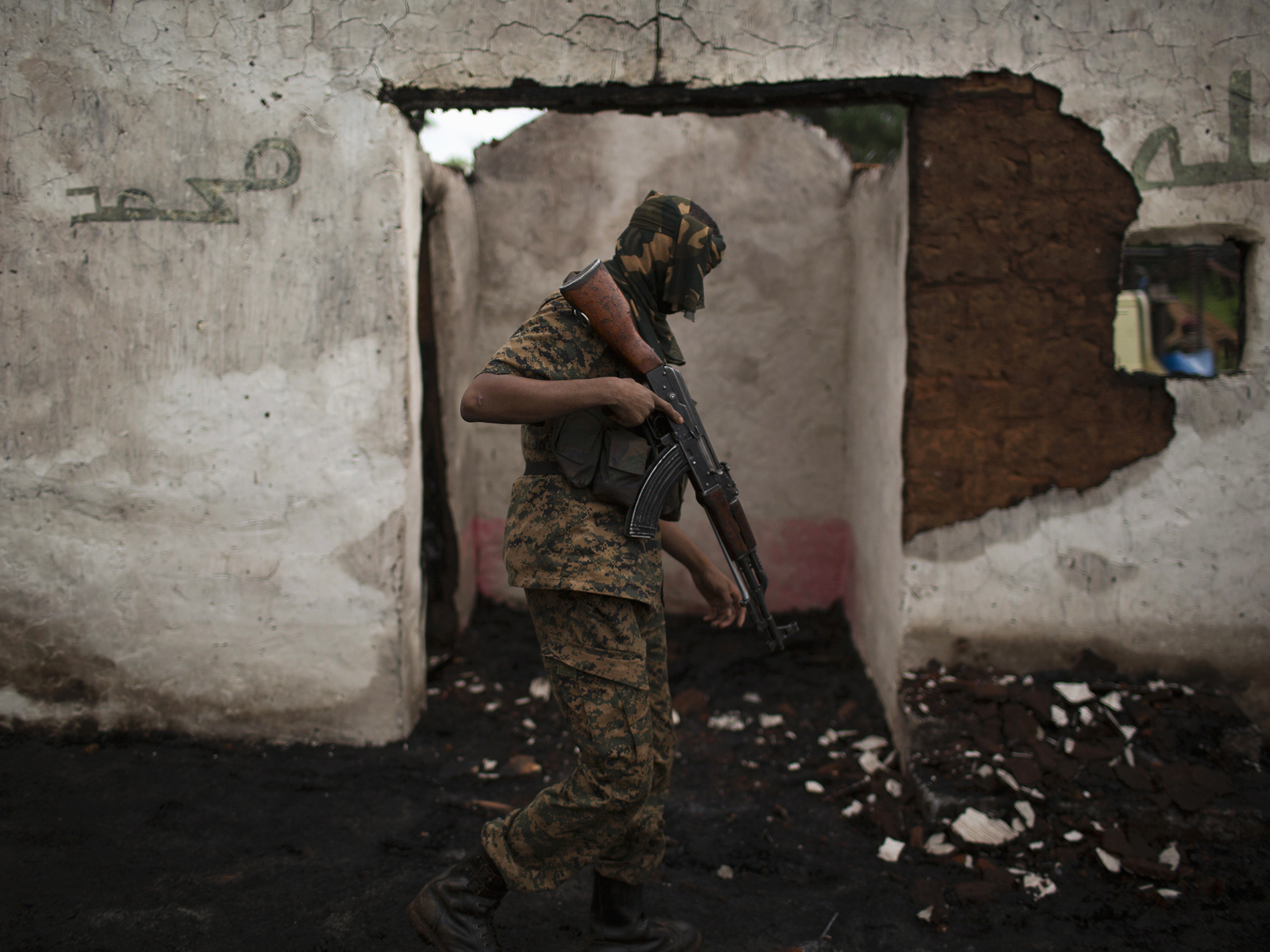 A former Seleka soldier stands in the ruins of a mosque, which residents say was attacked and burned by anti-Balaka militiamen, about 16 miles from Bambari.