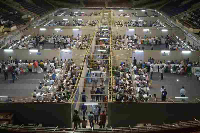 Indian election officials, polling agents and observers gather as electronic voting machines are examined in Kolkata on May 16.