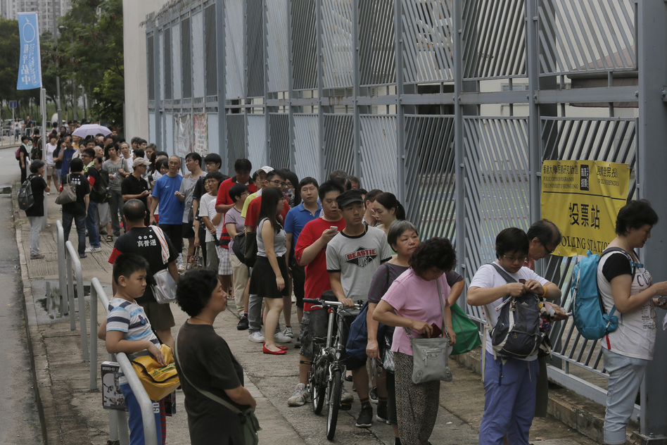 People queue at a polling center to vote in an unofficial referendum on democratic reform in Hong Kong on Sunday, June 22, 2014. (Vincent Yu/AP)