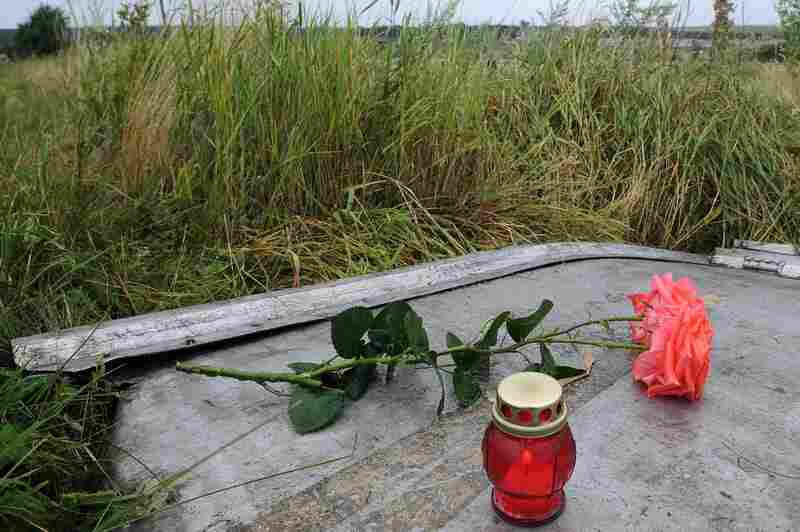 A candle and a rose are placed on a piece of debris at the site of the crash.