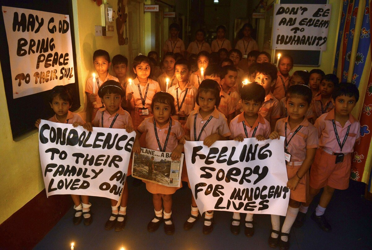 Indian schoolchildren hold candles and prayer messages for those killed in the crash of a Malaysia Airlines plane carrying 298 people from Amsterdam to Kuala Lumpur.