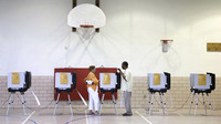 An official assists a voter at a polling station inside Fort Garrison Elementary School in Pikesville, Md., on primary day, June 24. As in many states this primary election season, turnout was low in Maryland.