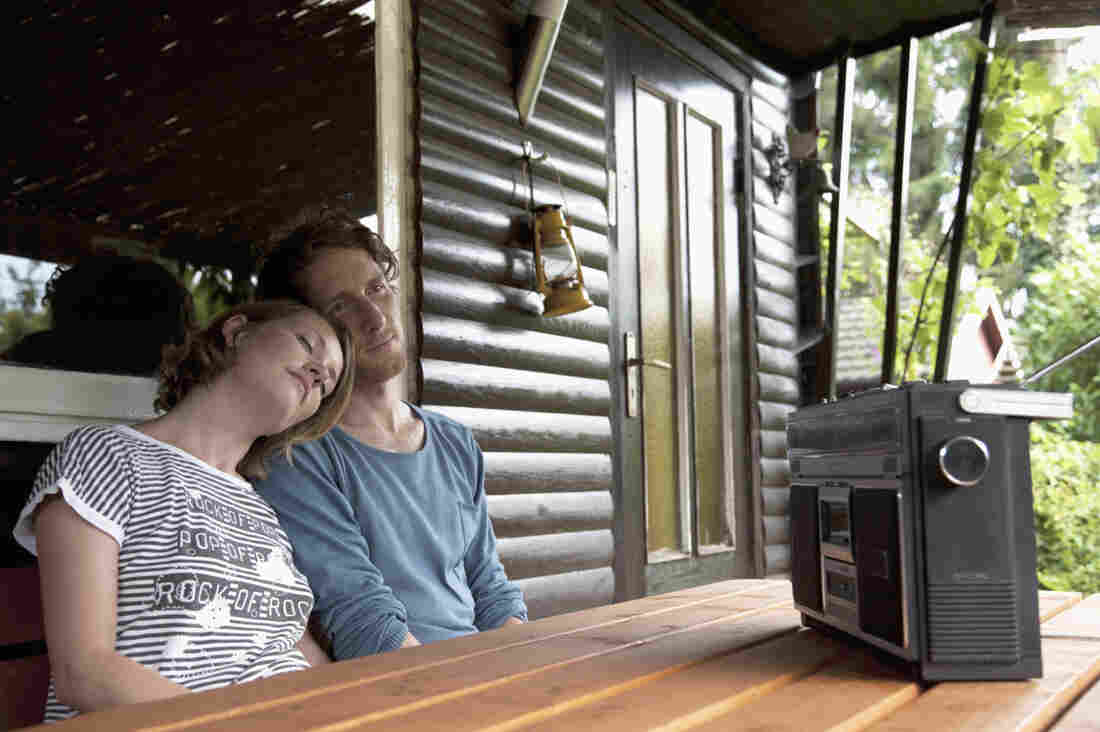 Germany, Hamburg, Man and woman listening to radio in cottage at allotment garden
