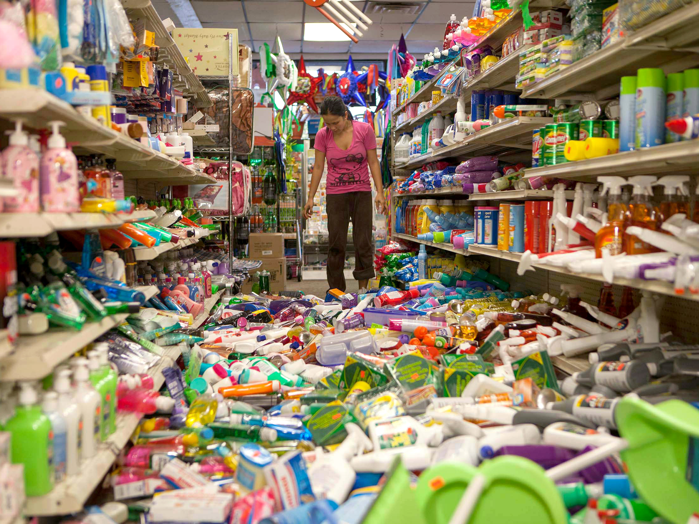 Nina Quidit cleans up the Dollar Plus and Party Supplies Store in American Canyon Calif. after the quake on Sunday.