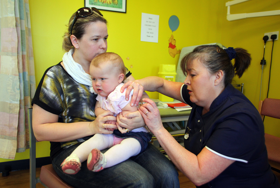 Helen Down holds her 14-month-old daughter, Amelia, for an MMR shot in Swansea, Wales, April 2013. The vaccination was in response to a measles outbreak. (Geoff Caddick/AFP/Getty Images)