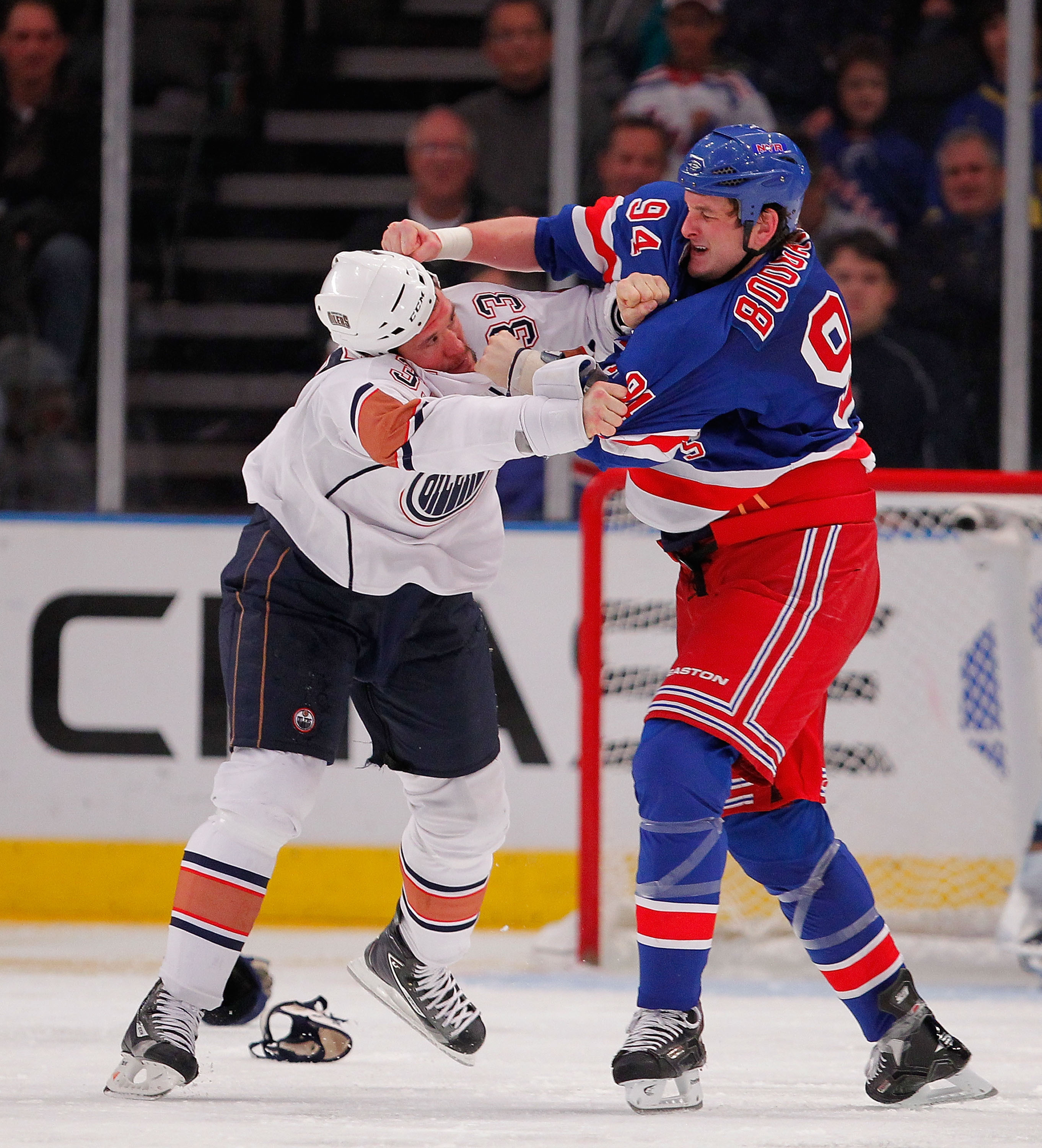 Steve MacIntyre of the Edmonton Oilers (left) fights with Derek Boogaard of the New York Rangers during a game in November 2010 in New York City.