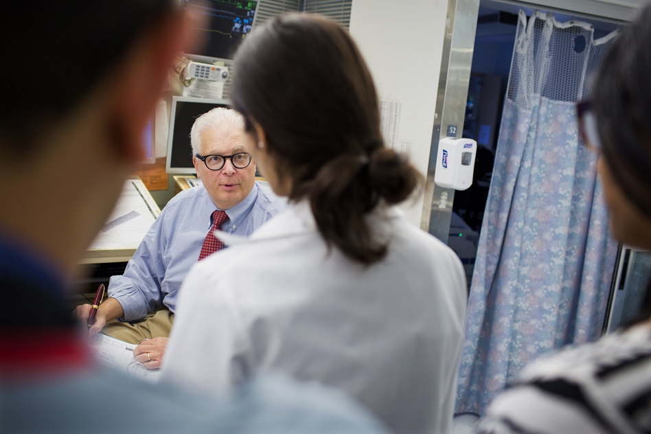 Dr. Allan Ropper speaks with residents and fellows as they do rounds at the neuroscience intensive care unit at Brigham and Women's Hospital in Boston. (M. Scott Brauer for NPR)